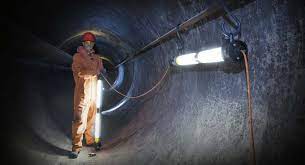 Image of man setting up lighting in a confined space